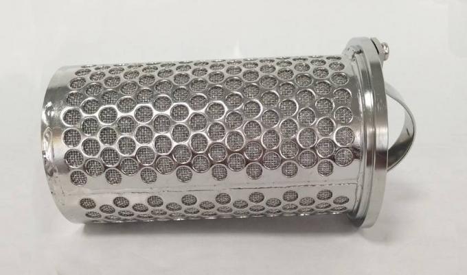 Una cesta sinterizada metal perforado del filtro está mintiendo en el fondo gris.